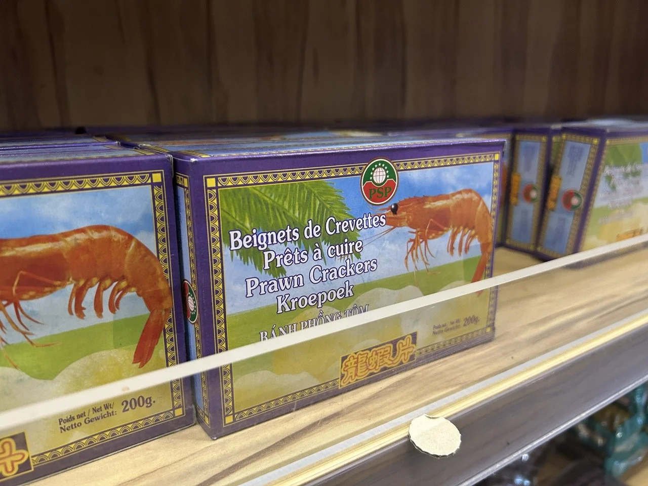 Boîte de crackers aux crevettes avec une illustration de crevette sur l'emballage sur une étagère en magasin.