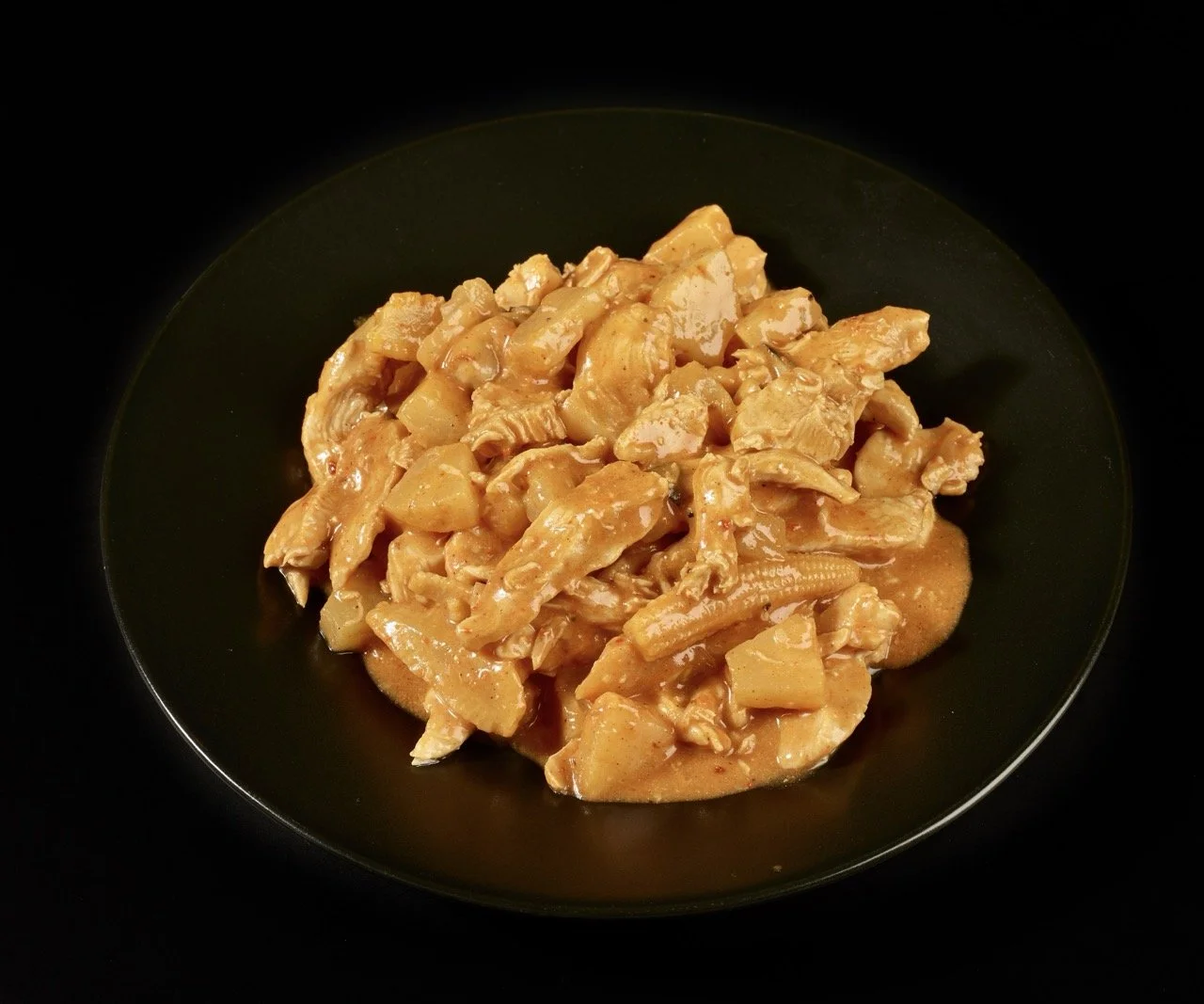 Plat de poulet en sauce dans un bol noir