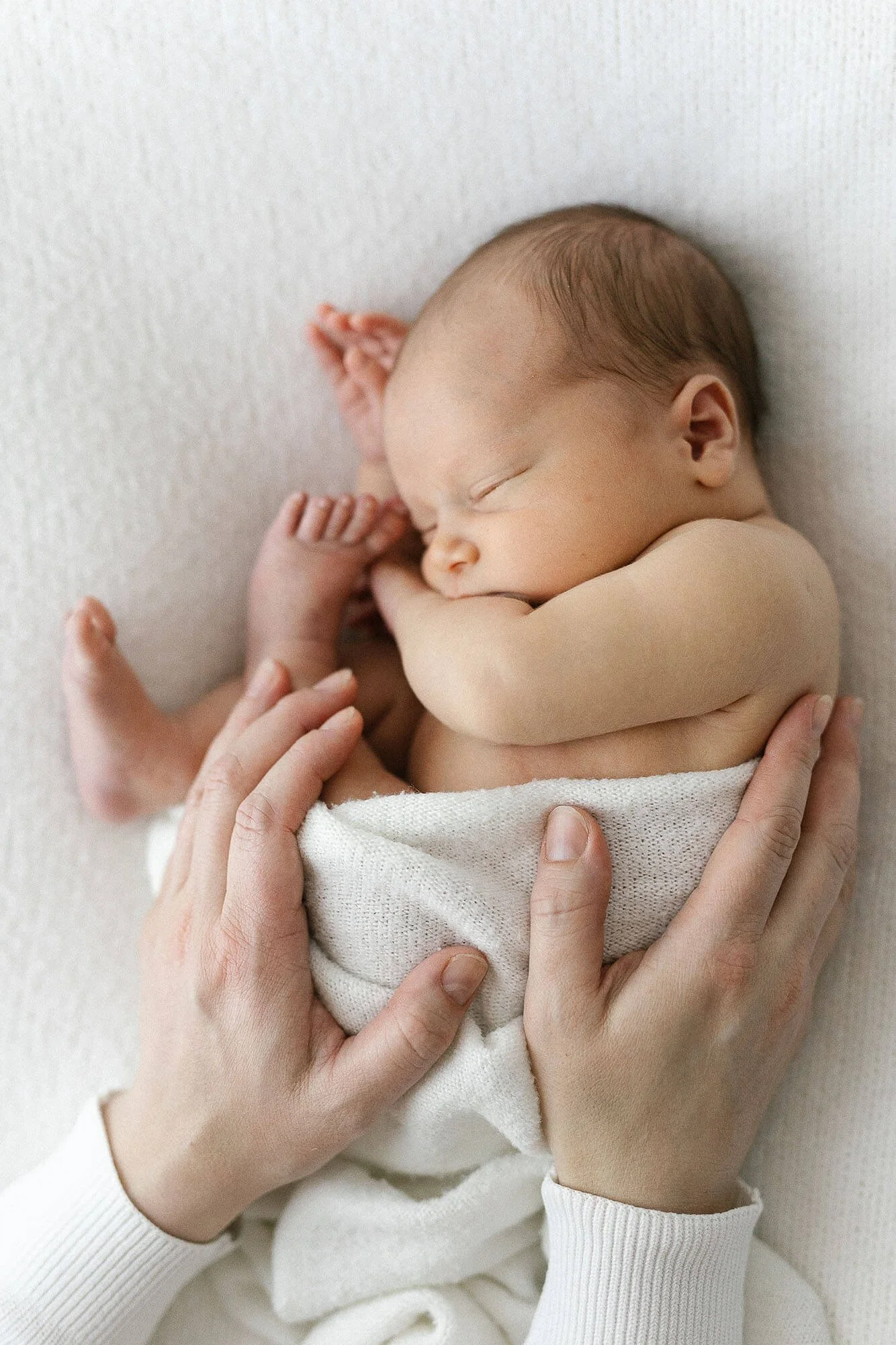 Newborn kuvaaja Oulu - hellästi äidin käsien suojassa