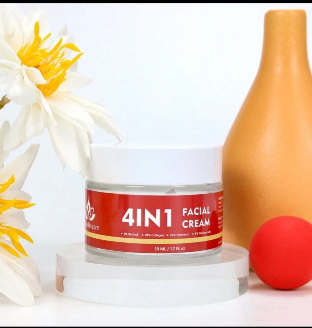 A jar of 4-in-1 facial cream with a white lid, placed on a white platform, with a gold vase and a red ball in the background, and white flowers on the left side.