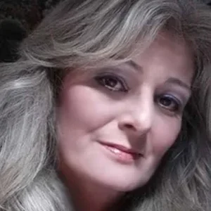 Close-up of a woman with blonde hair smiling at the camera.