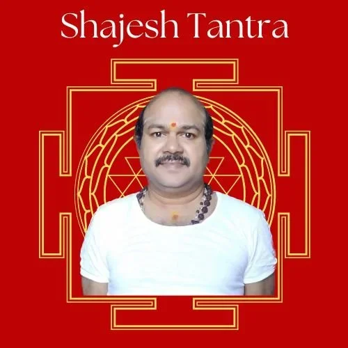 A man with a mustache and a forehead dot wearing a white shirt and a necklace, set against a red background with a geometric pattern and the text 'Shajesh Tantra' at the top.