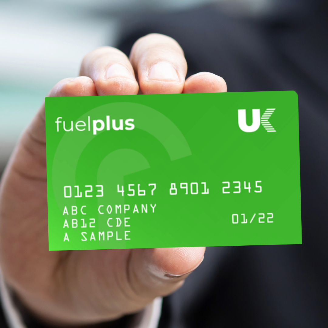 Hand holding a green fuel card with the words "fuel plus" and "UK" logo, displaying sample numbers and company information.