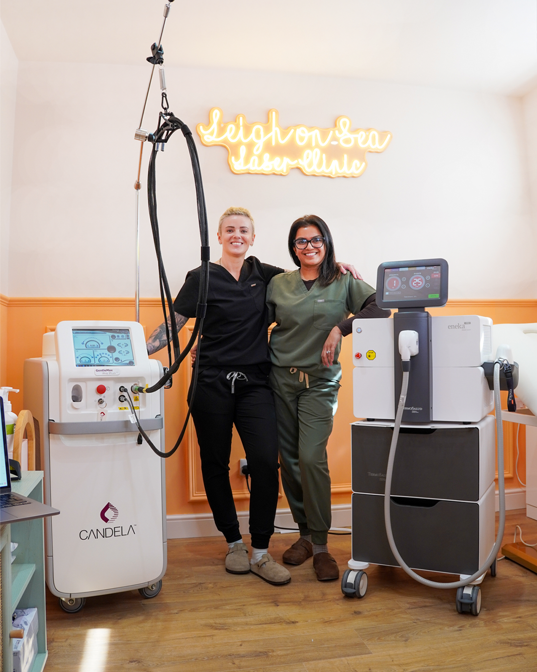 Rosie ane Sejal, expert laser technicians standing next to the Candela GentlePro Max Plus and Eneka Pro laser hair removal machines inside of Leigh on Sea Laser Clinic.