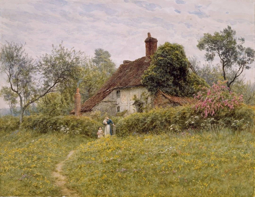 A rural scene with a thatched cottage, surrounded by trees and blooming flowers. A woman and a child walk along a path near the house during daytime.