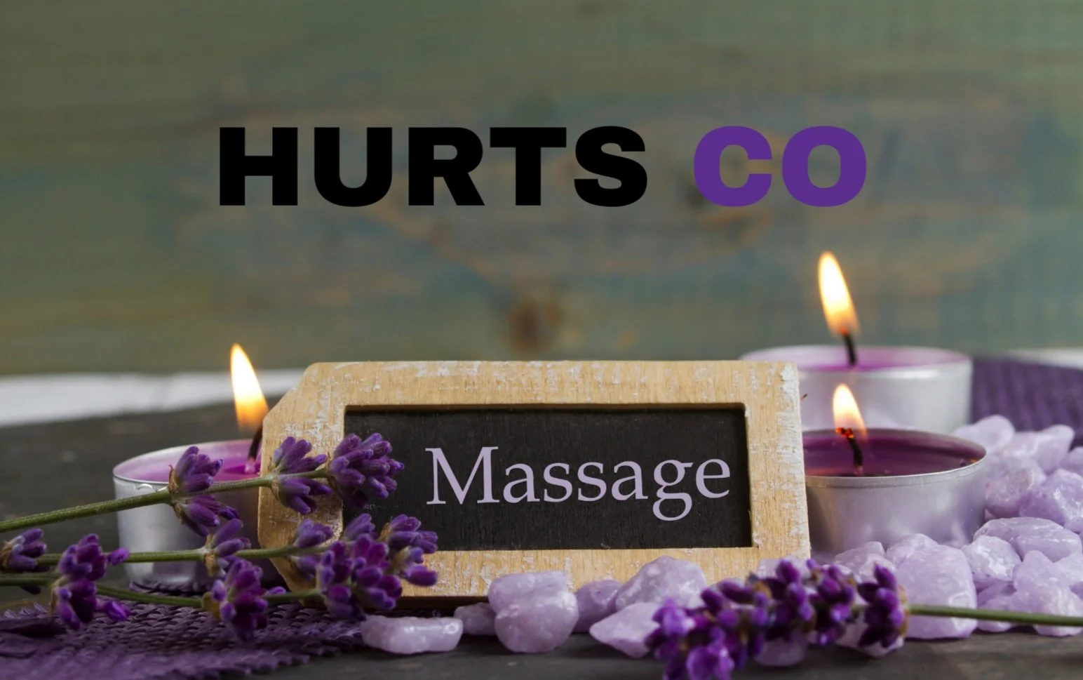 A spa scene with lit purple candles, purple stones, lavender flowers, a small sign reading 'Massage', and the text 'Hurts co' in bold black and purple letters above.