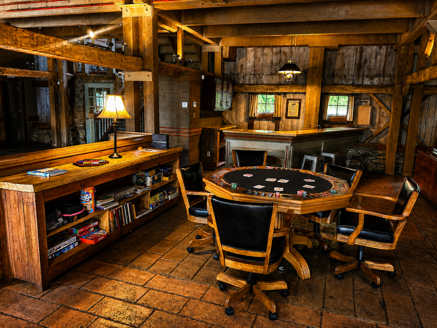 A cozy wooden game room with a circular poker table, chairs, a bar counter with a lamp, and shelves with board games and books. Natural light comes through small windows in a rustic setting.