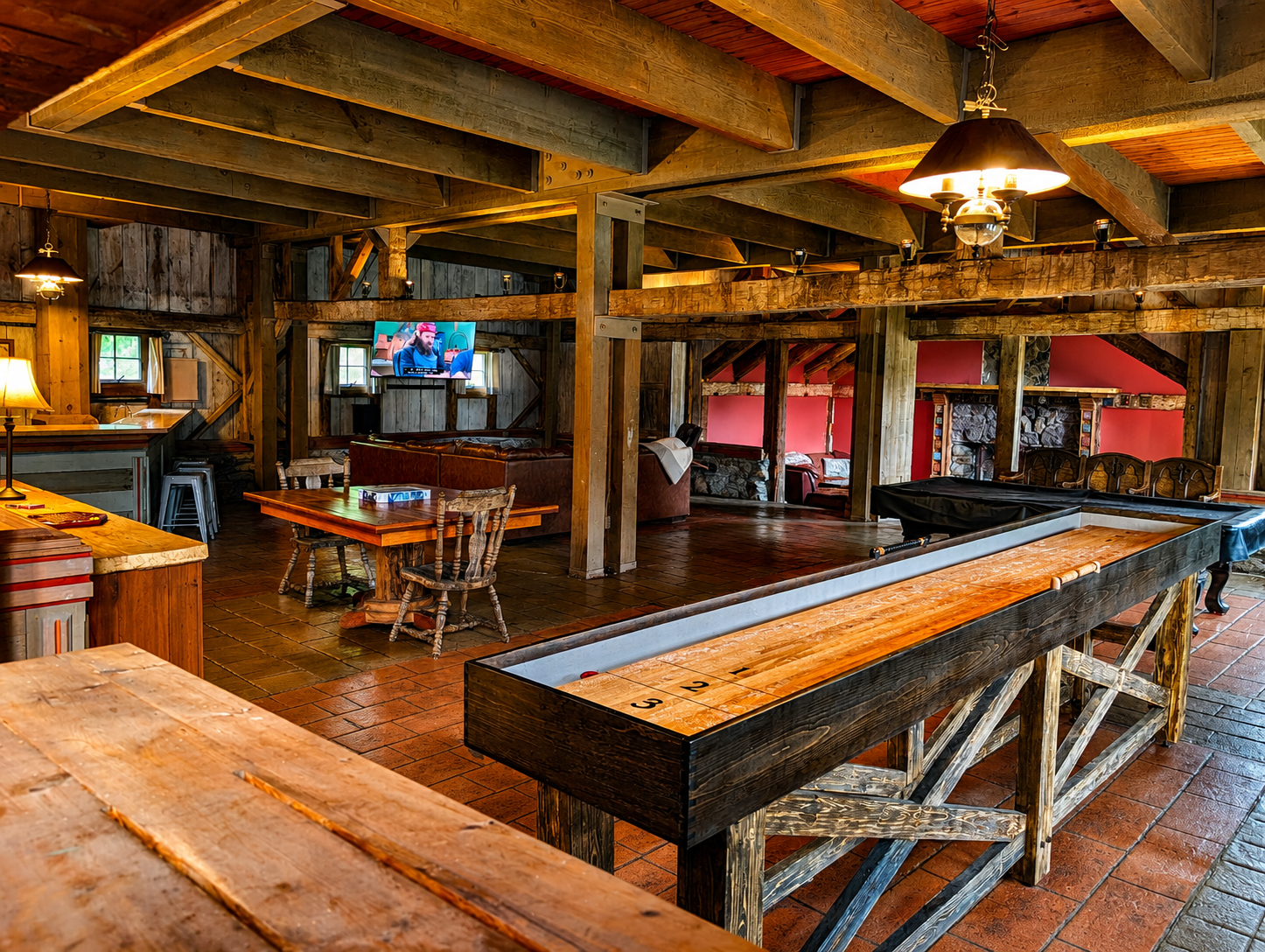 Interior of a rustic bar or restaurant with wooden beams, tables, and chairs, a shuffleboard table, a television, and decorative lighting.