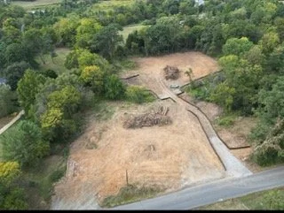 Aerial view of an archaeological site with excavated areas surrounded by trees and greenery.