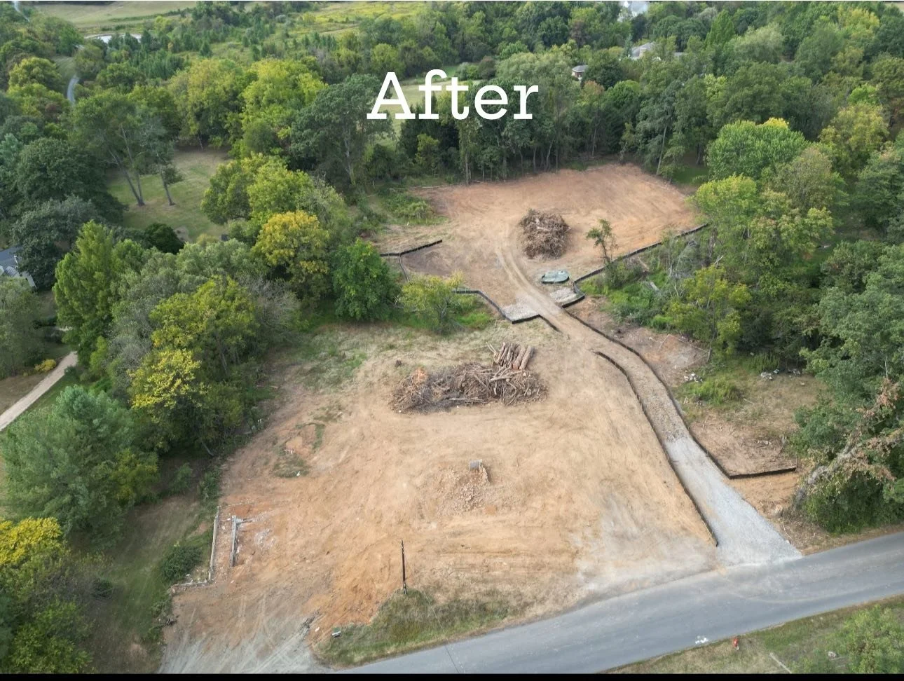 A cleared lot of land with a dirt driveway, surrounded by trees, with some logs and debris in the center, and labeled 'After' at the top.
