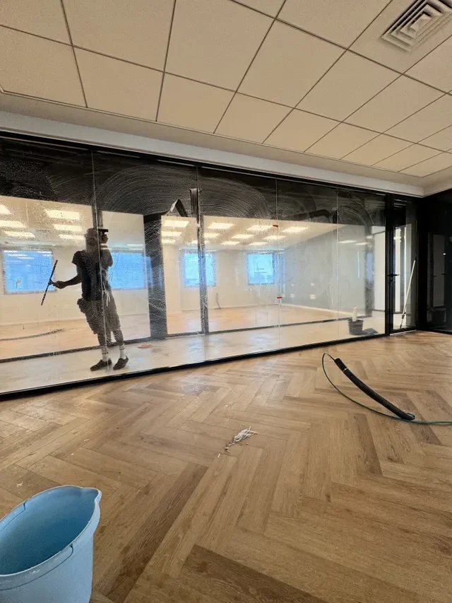 Professional commercial cleaner scraping company windows