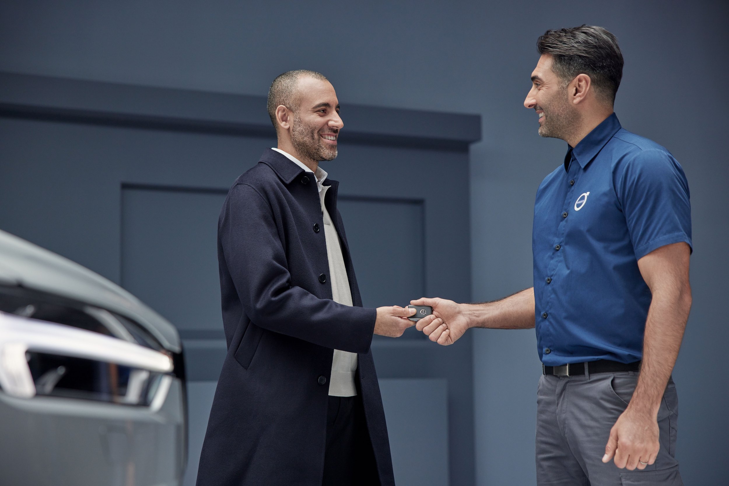 Car dealership agent handing out car keys to customer