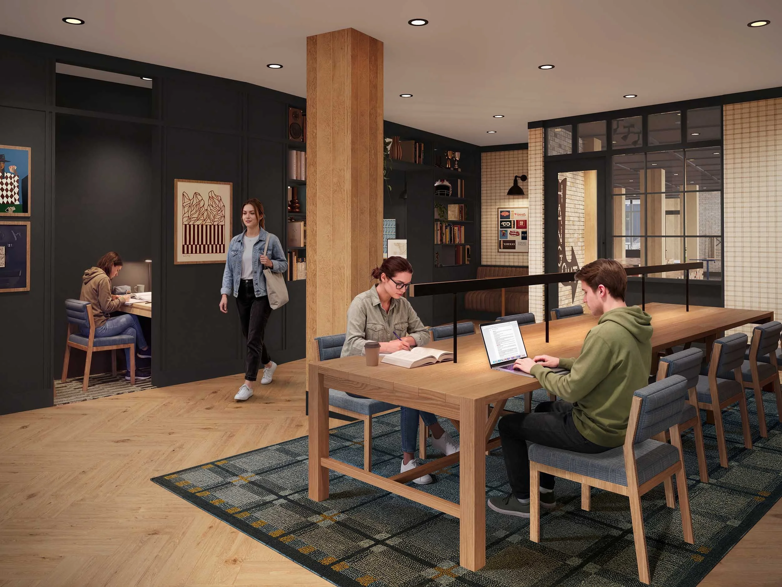 People working and walking inside a modern library or coworking space with dark walls, wooden accents, a bookshelf, and artwork.