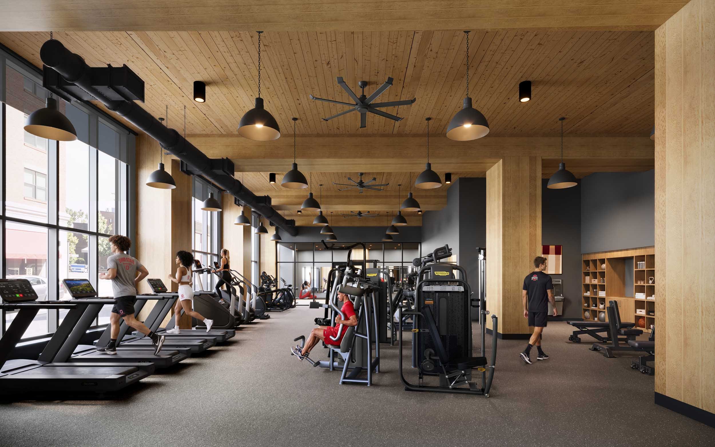 People working out on treadmills and using gym equipment in a modern fitness center with wood-paneled ceiling and large windows.