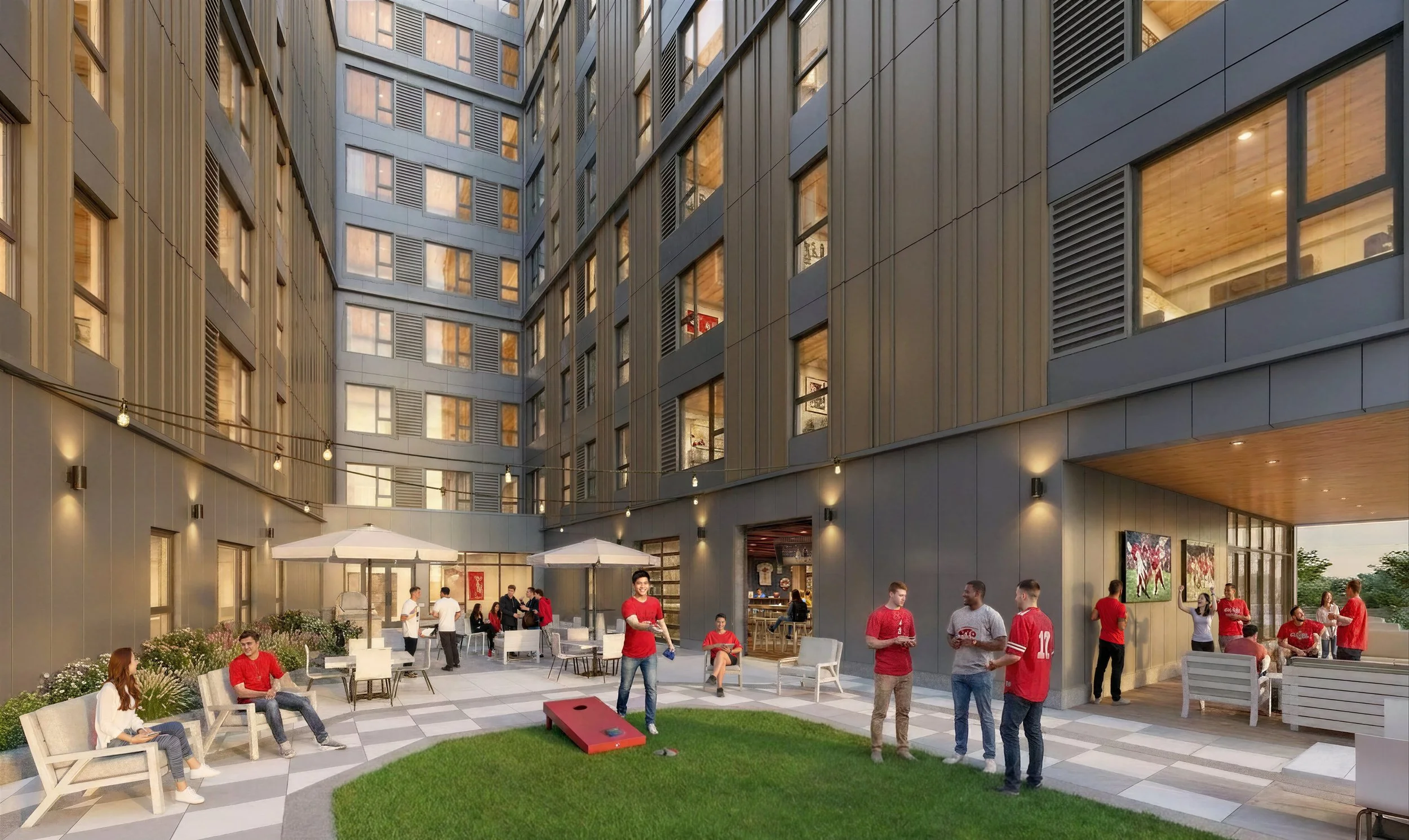 People playing cornhole in an outdoor courtyard surrounded by a modern multi-story building with large windows and patio furniture.