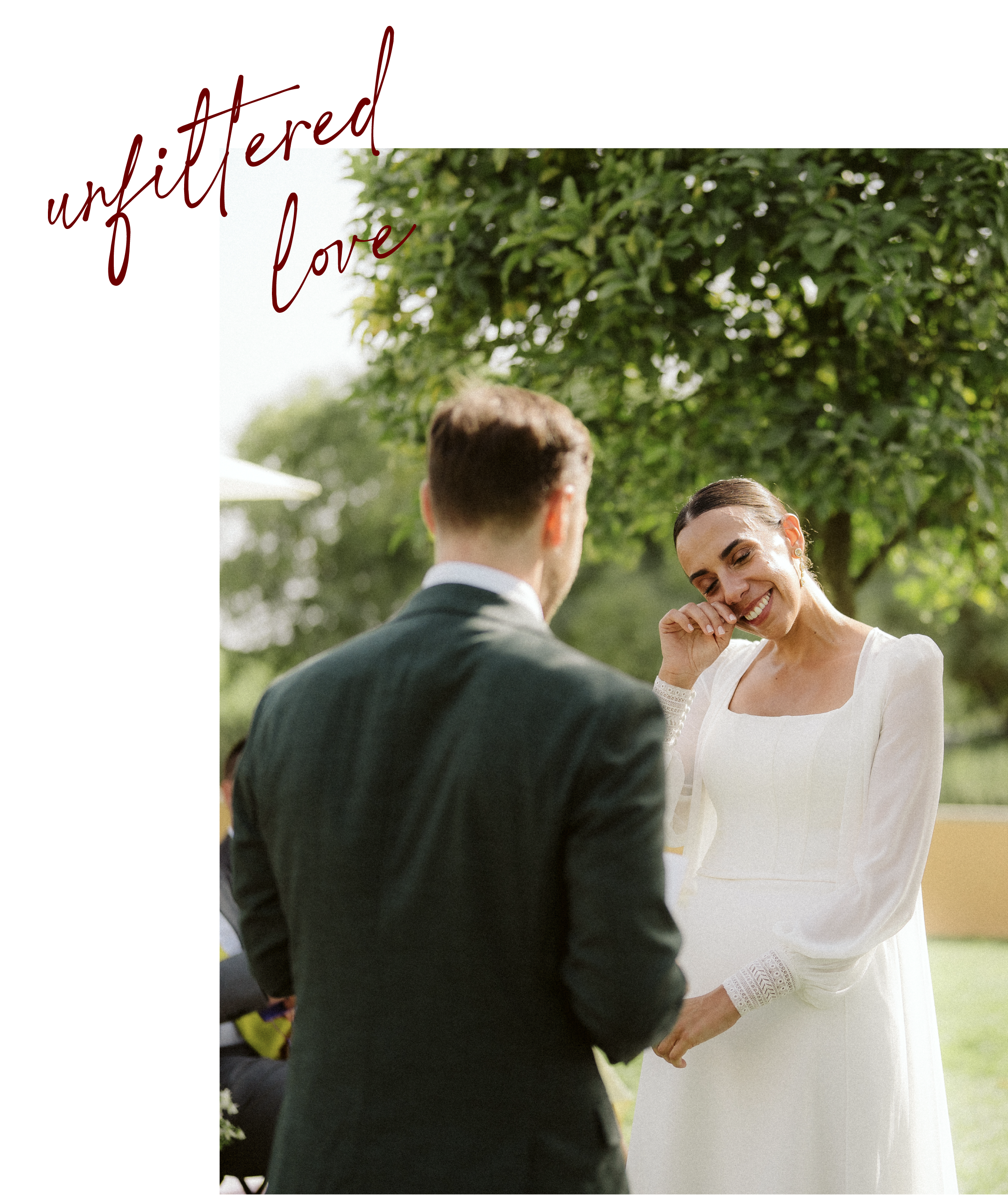 Outdoor wedding couple, the woman smiling, crying and touching her face, while the man, seen from behind, is wearing a suit.