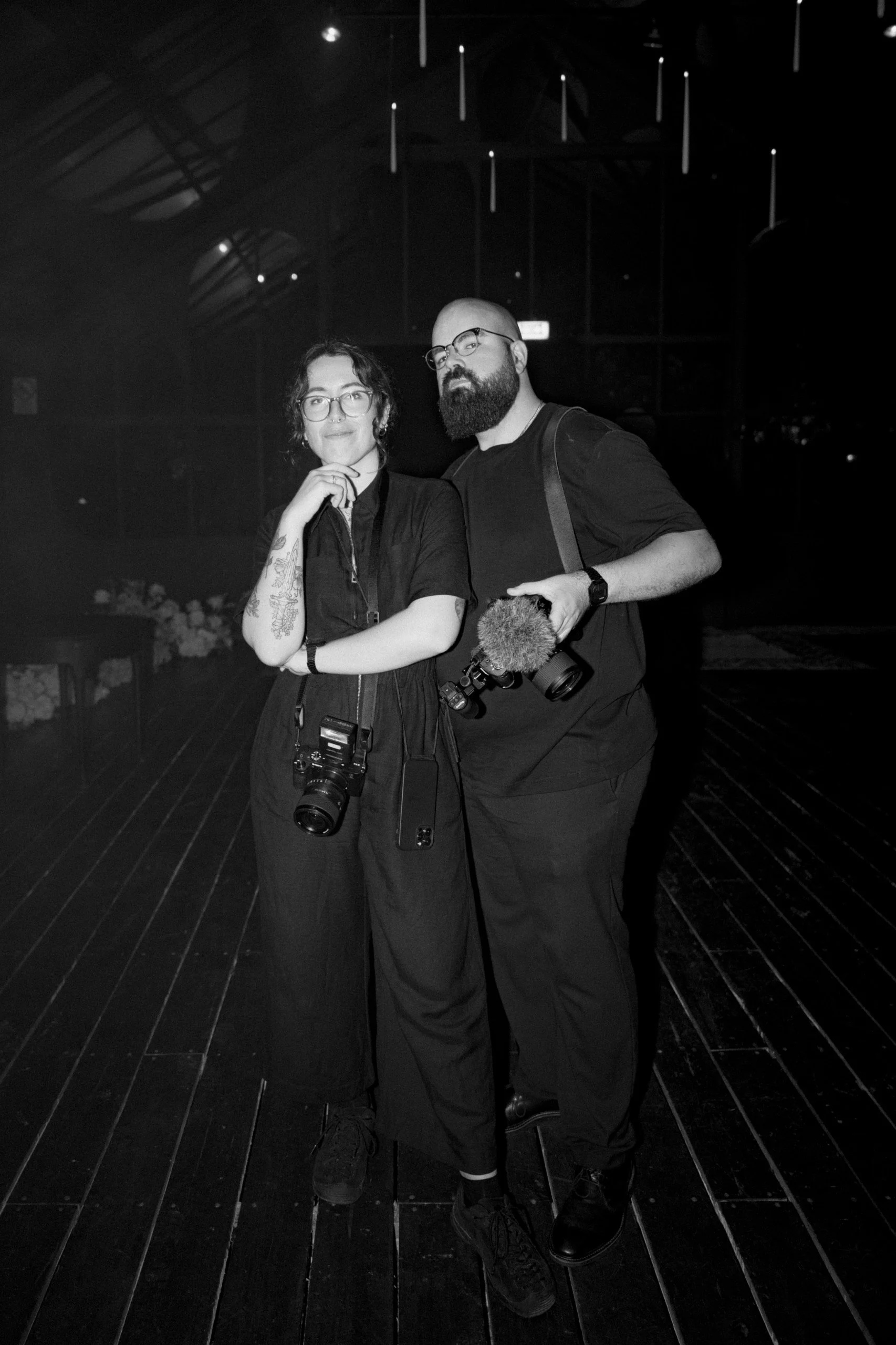 Couple of photographers holding cameras during a wedding.