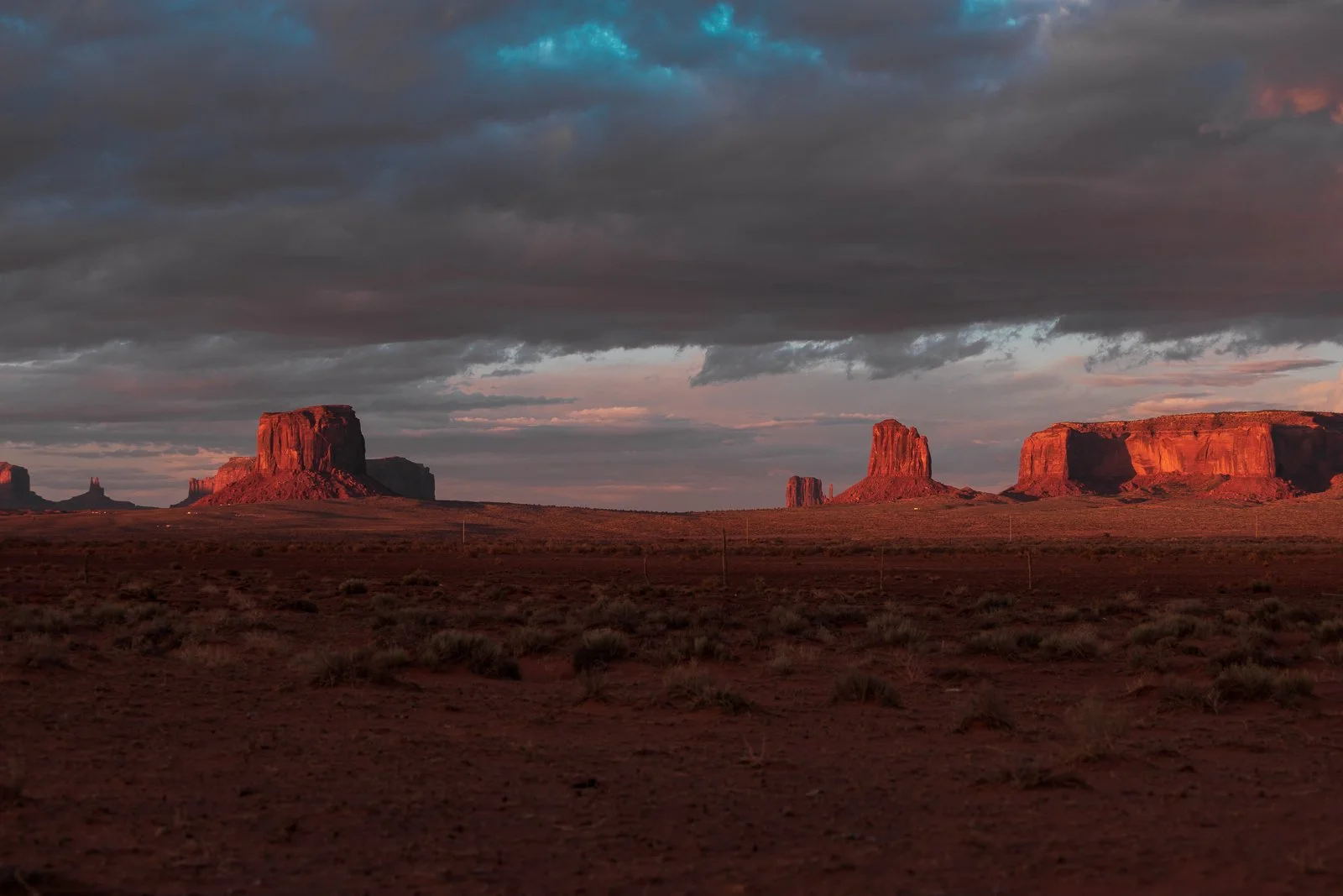 Paysage désertique avec de grandes formations rocheuses rouges sous un ciel nuageux