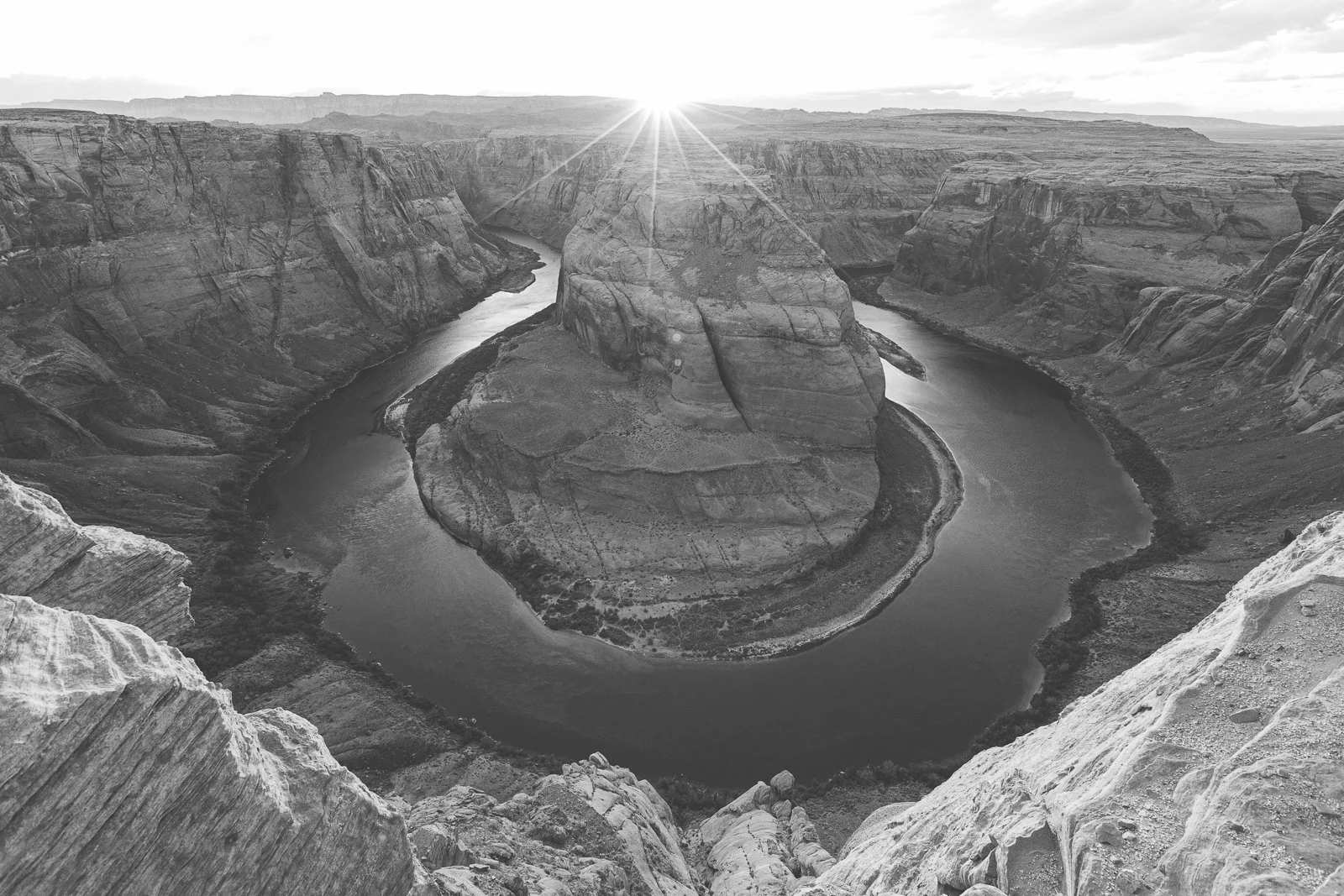 Photo en noir et blanc du Canyon du Colorado avec l'effet du soleil levant au sommet de la formation rocheuse