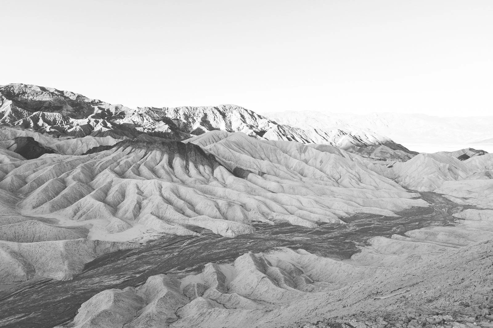 Paysage désertique avec montagnes rocheuses et canyon profond, en noir et blanc