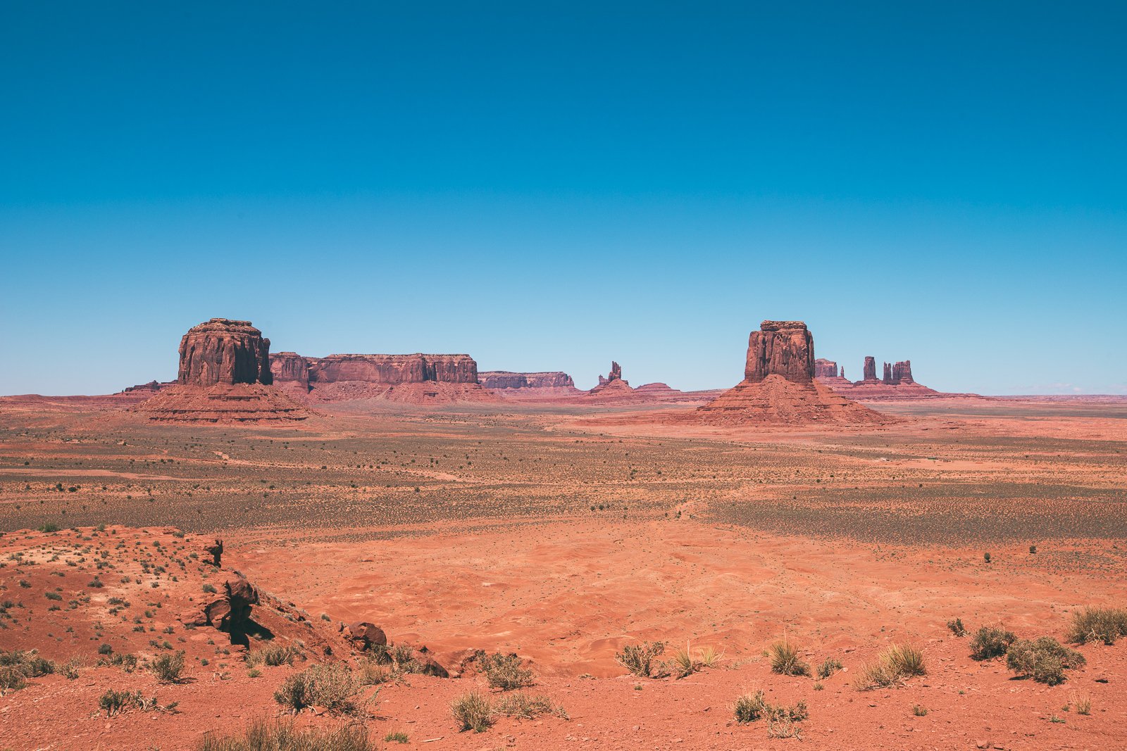 Paysage désertique avec des formations rocheuses en Arizona, sous un ciel bleu clair.