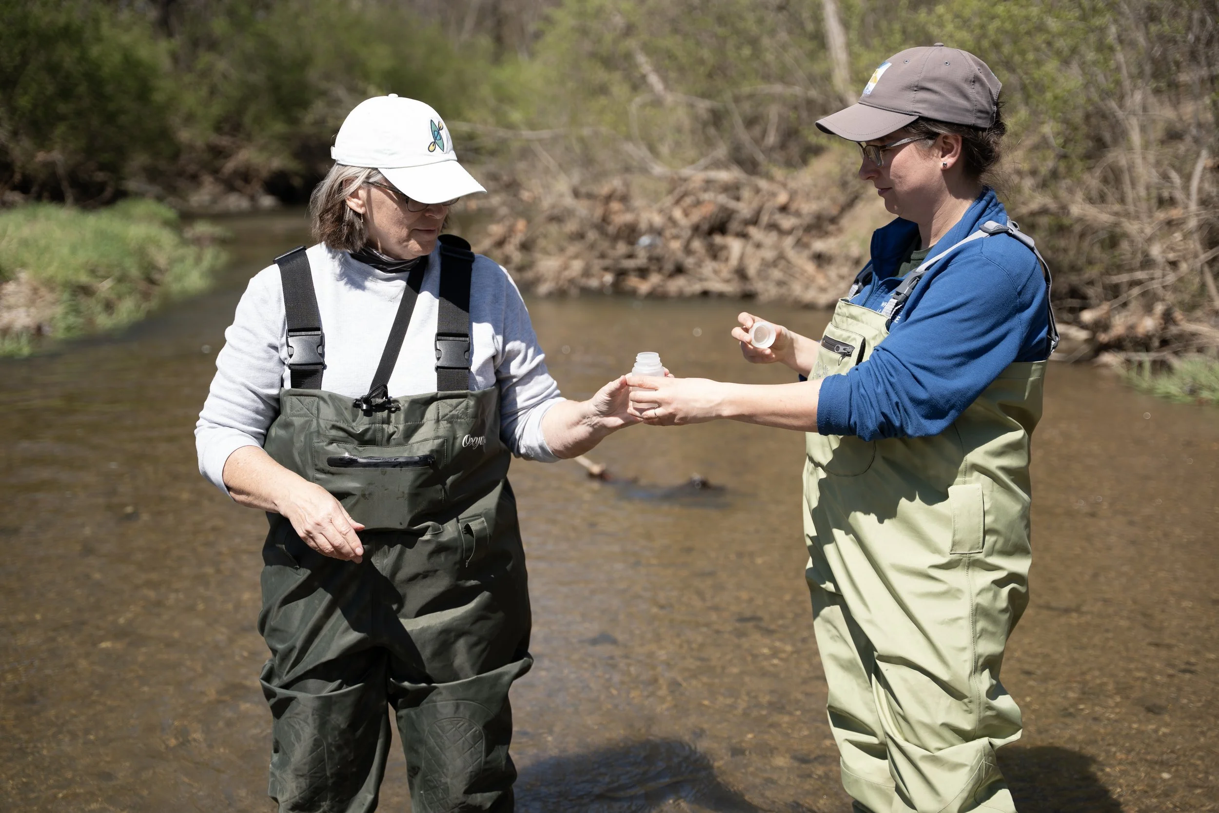 Rebecca Rees and Kelly Brown prepare a container for water samples at Honey Creek on Sunday, March 29, 2026, in Martinsville, Ind.