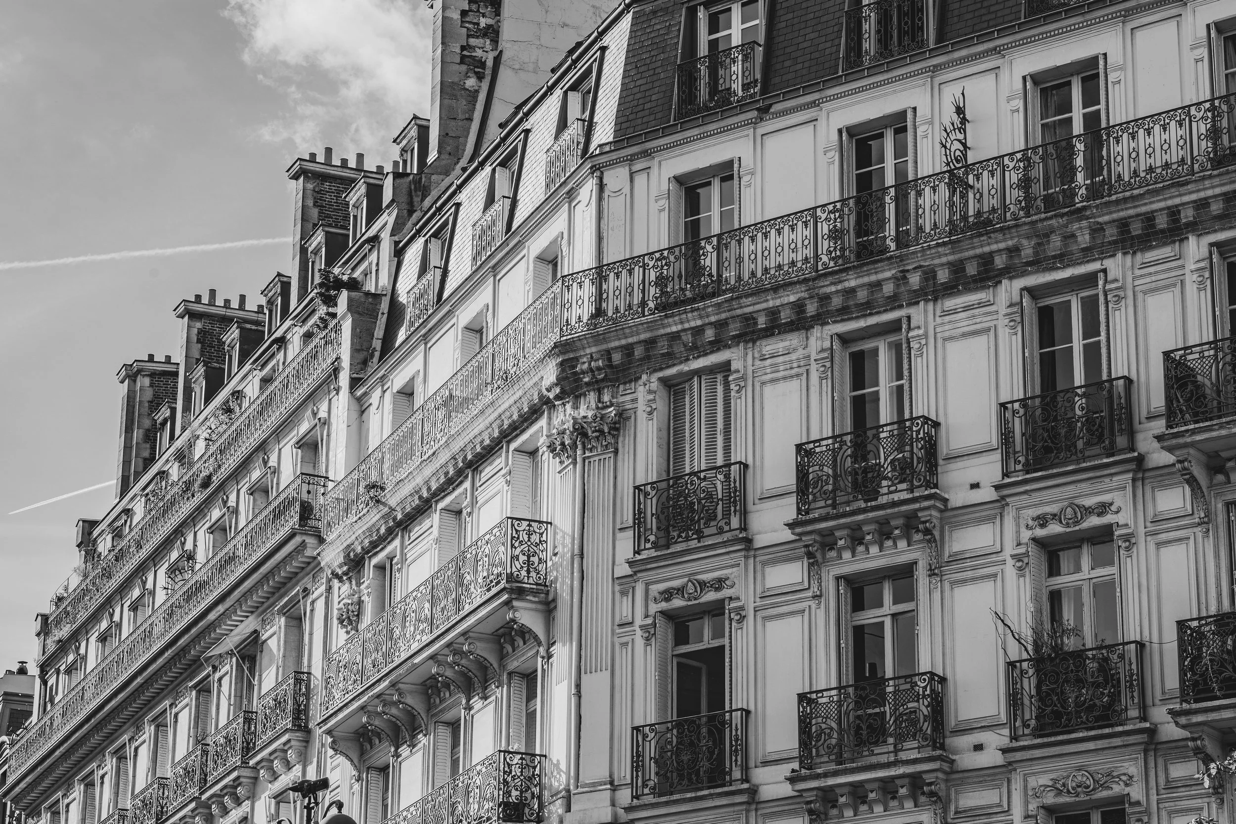 Edificio con finestre e balconi in stile parigino, in bianco e nero.