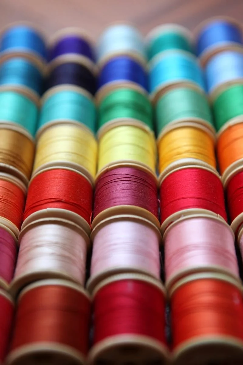Rows of colorful sewing thread spools arranged in a pattern.