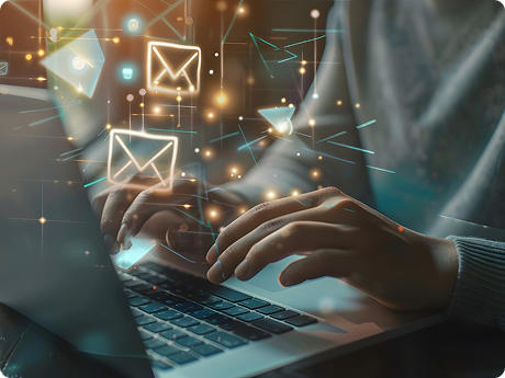 Person typing on a laptop with digital email icons and abstract data graphics floating above the keyboard.