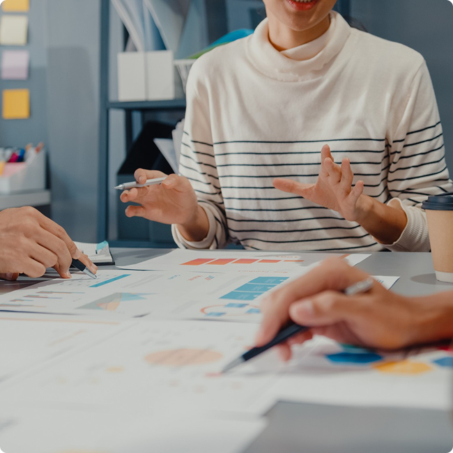 People discussing business charts and graphs in an office setting.