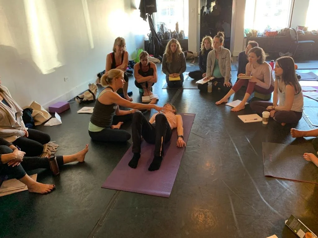 Louisa, founder at Move Well Studio demonstrates core alignment during a restore your core course