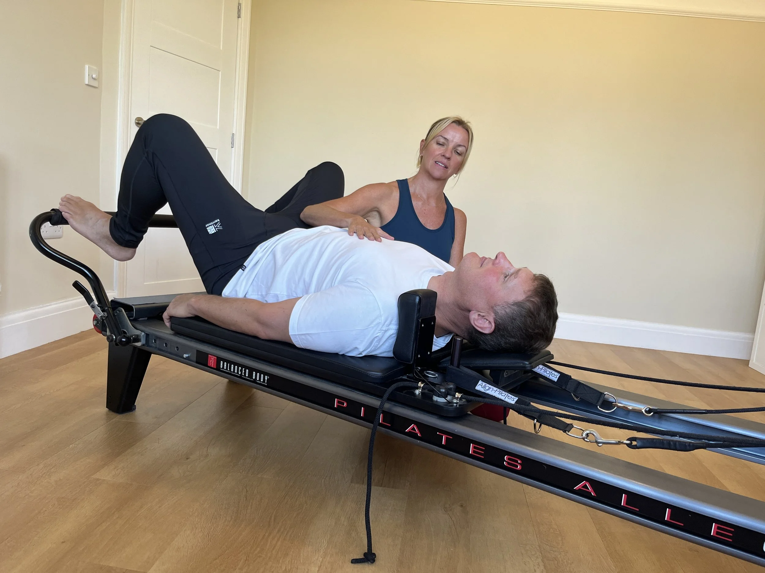 Louisa, founder at Move Well Studio demonstrates a standing position during a pilates class in Wetherby