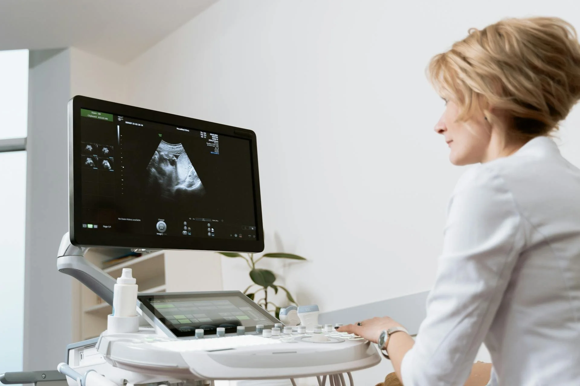 Doctor looking at the screen while performing pregnancy test