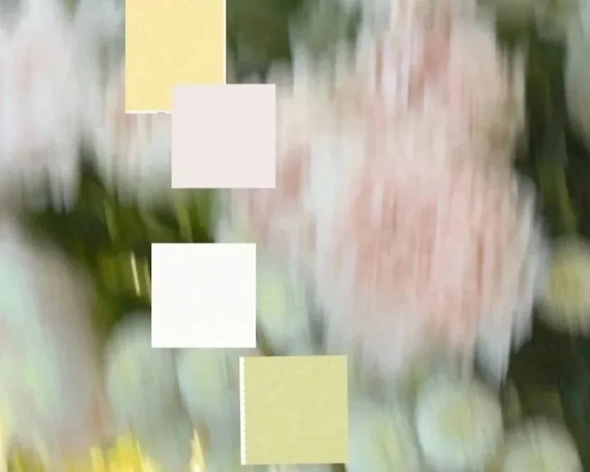 Blurred image with some sticky notes or paper squares attached to a surface, with colors including yellow, white, and green.