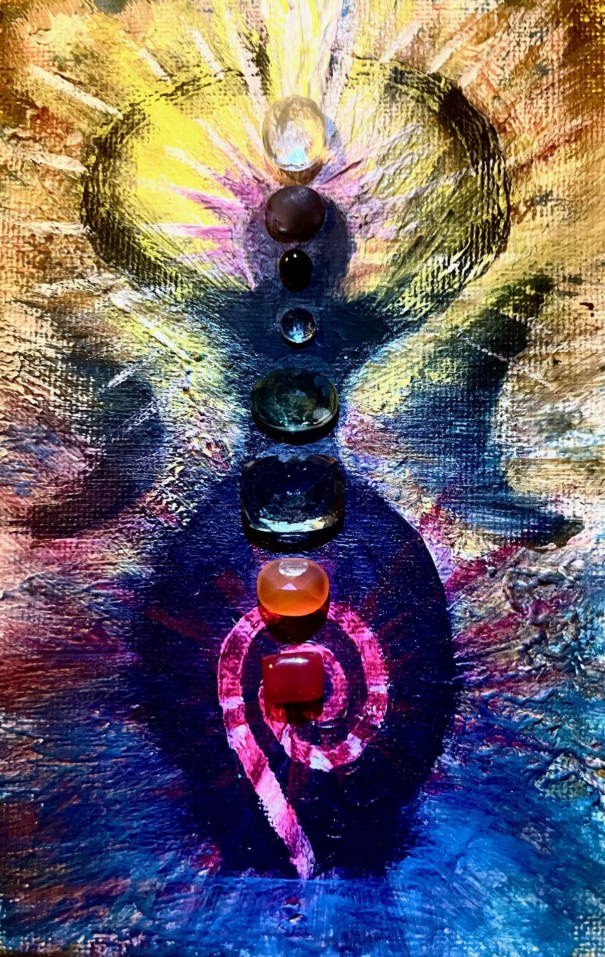 Colorful abstract painting featuring a vertical sequence of small, rounded gemstones aligned with a pink, painted spiral and circle design on a textured background.