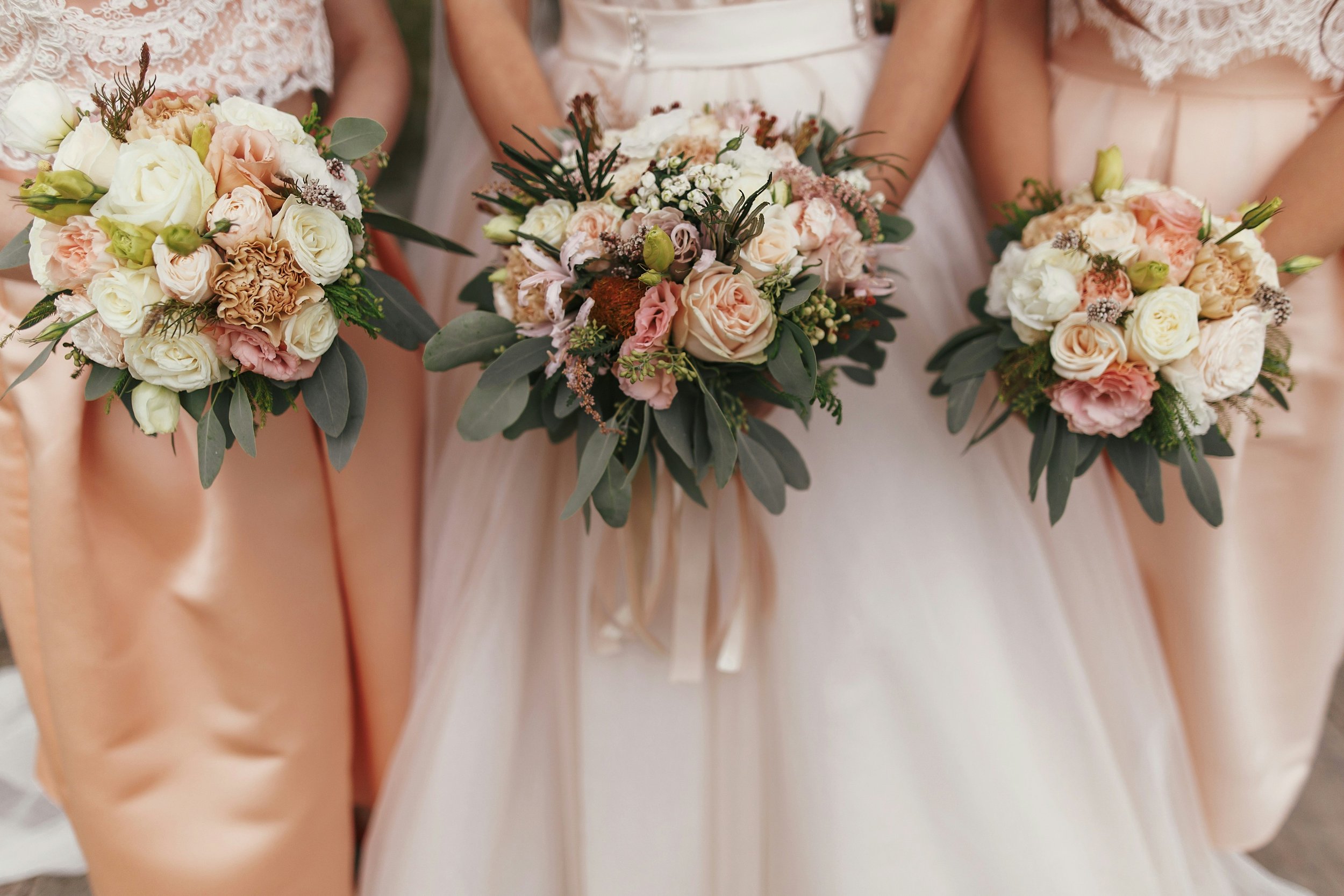 Brautstrauß und Brautjungfernsträuße in Creme und Apricot, abgestimmt auf das Farbkonzept der Hochzeit