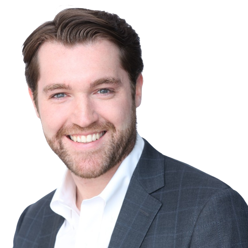 A young man in a dark suit and white shirt smiling showing teeth