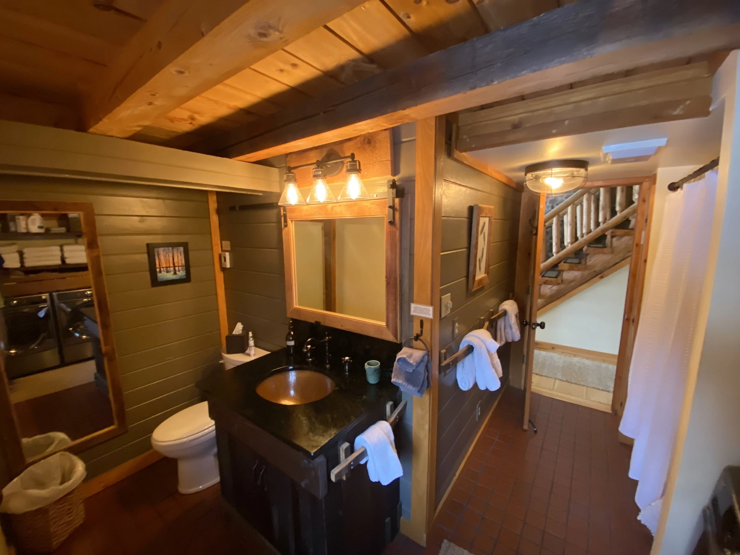 The bathroom, grounded in wood and stone.
