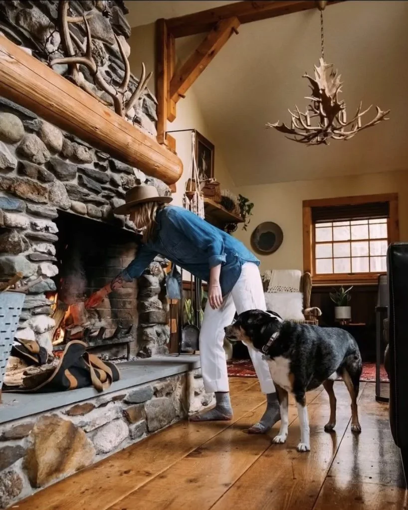 Lighting the fire, with a quiet companion close by.