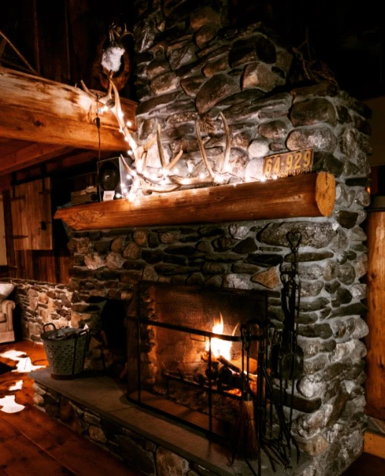 The stone fireplace, steady and welcoming in any season.
