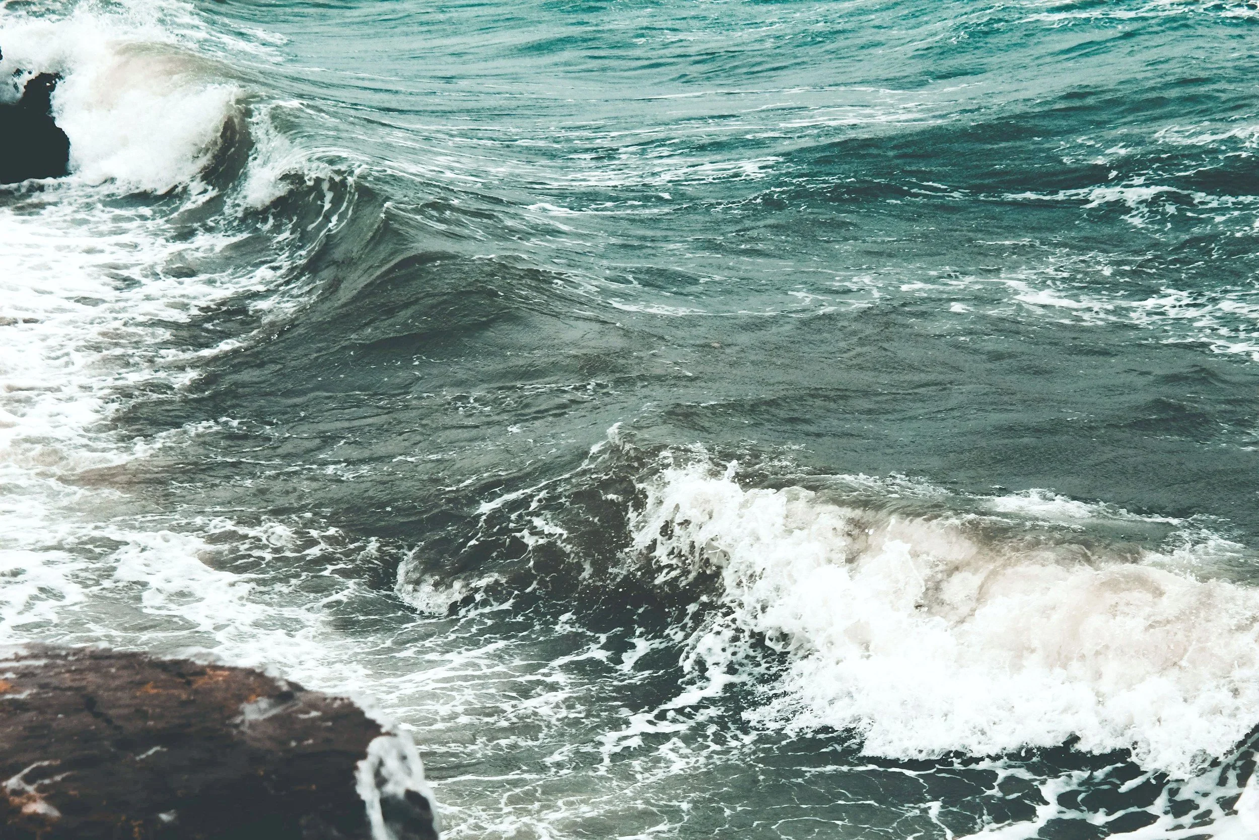 Das Bild zeigt das Meer mit Wellen, die gegen die Küste schlagen.