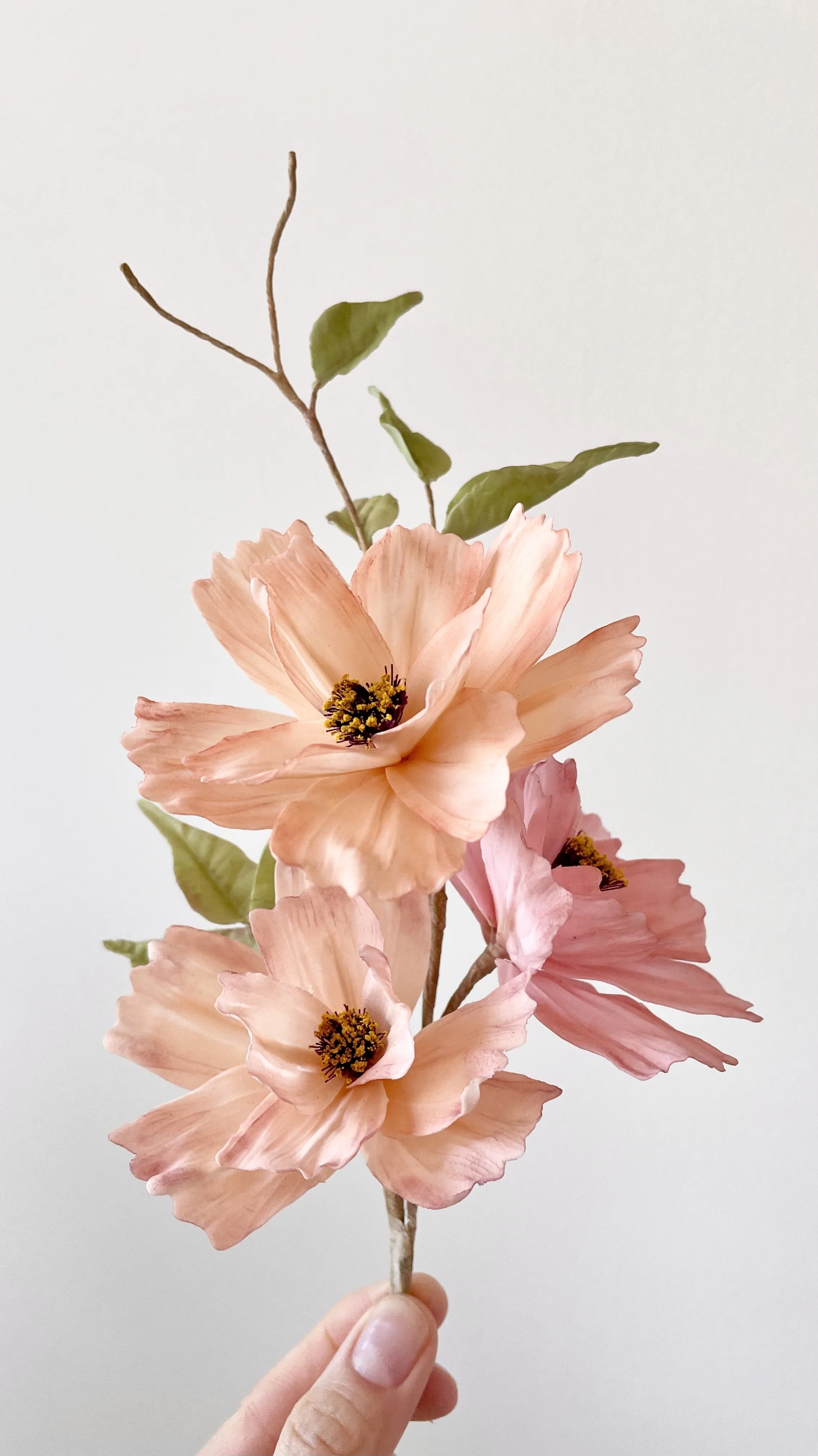 A hand holding handmade sugar flowers