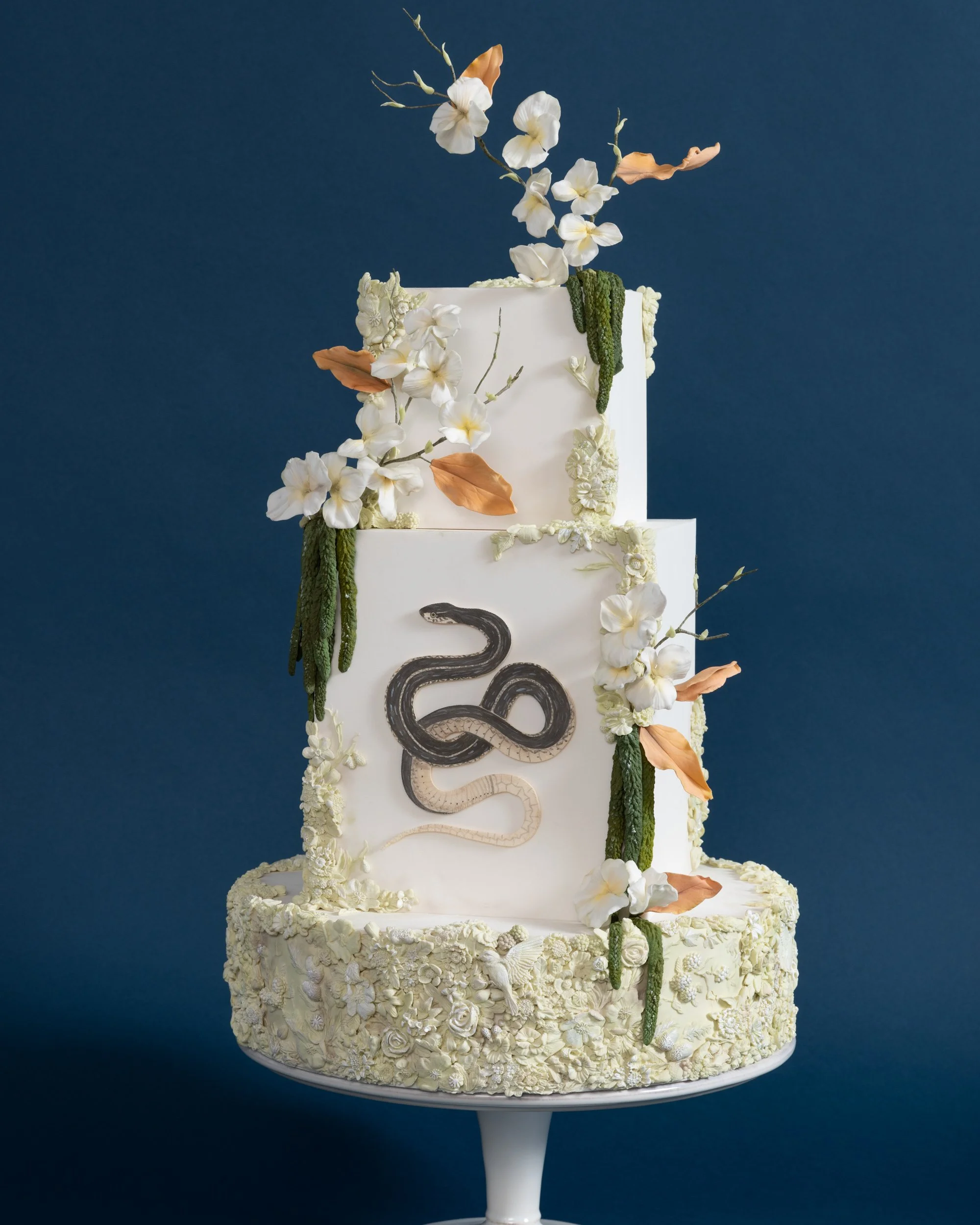 Aged garden with snake and amaranthus on square wedding cake