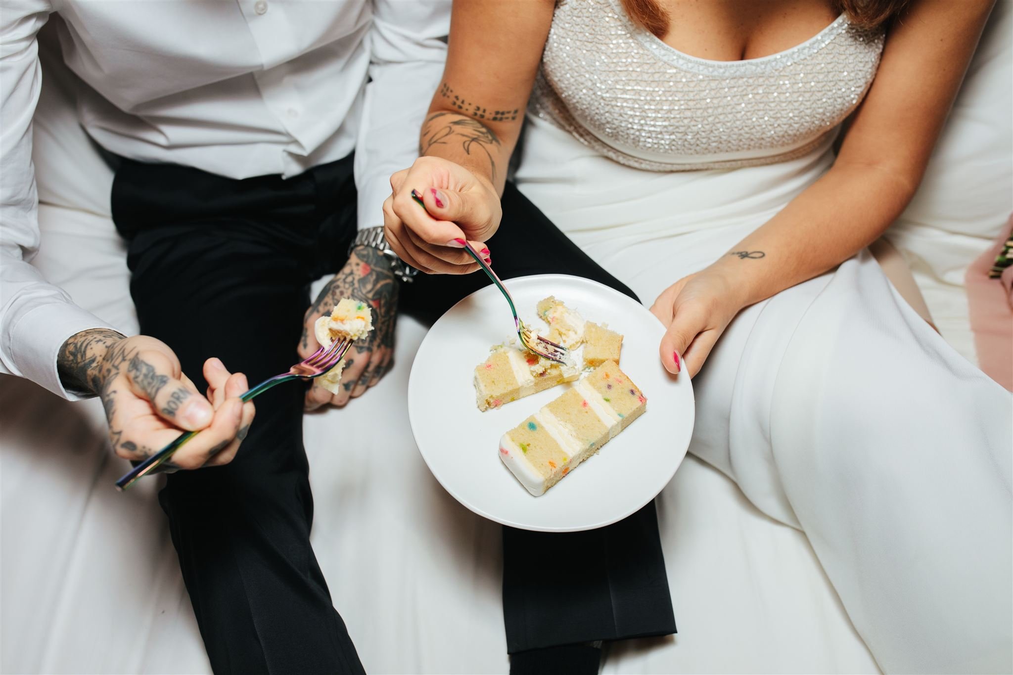Couple eating wedding cake by Sylvie the Camera