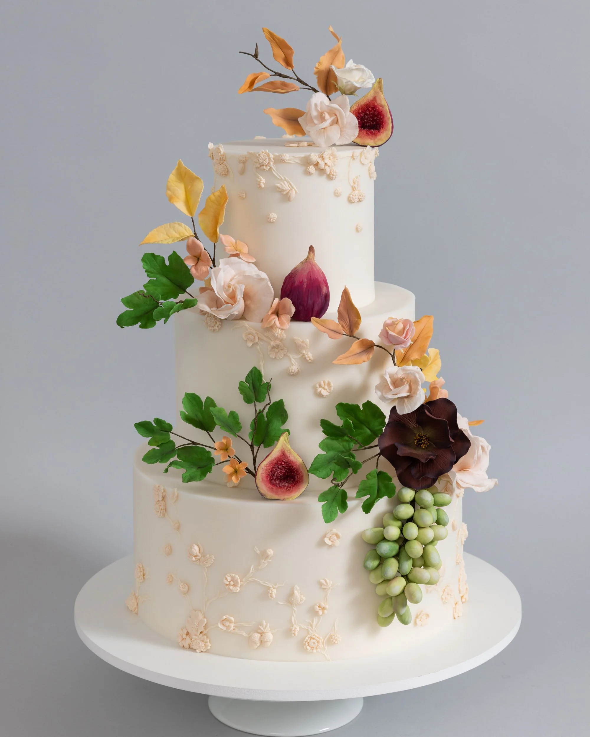 Bas relief wedding cake and handmade figs, grapes, and roses
