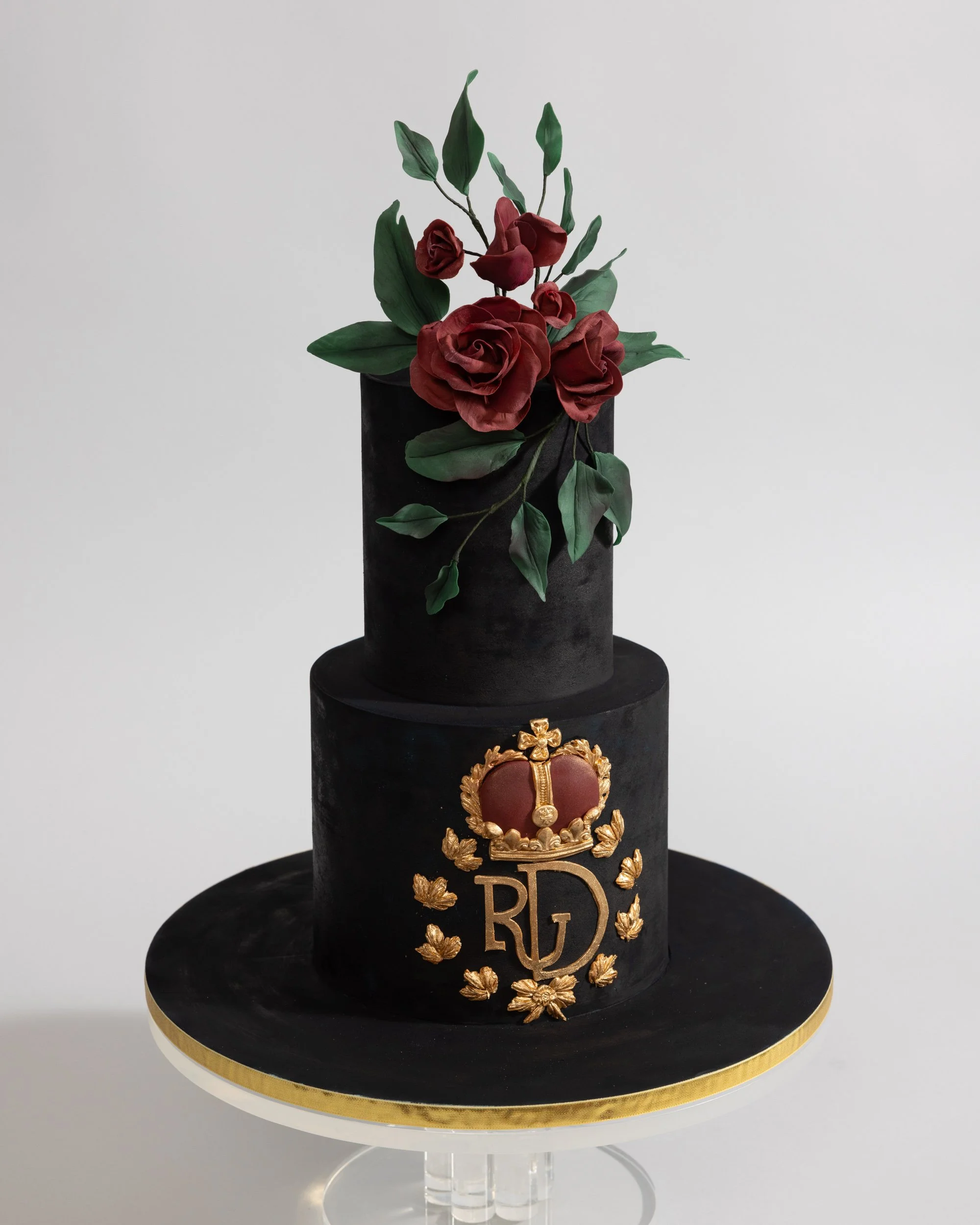 Dark blue flocked birthday cake with heraldry and dark roses