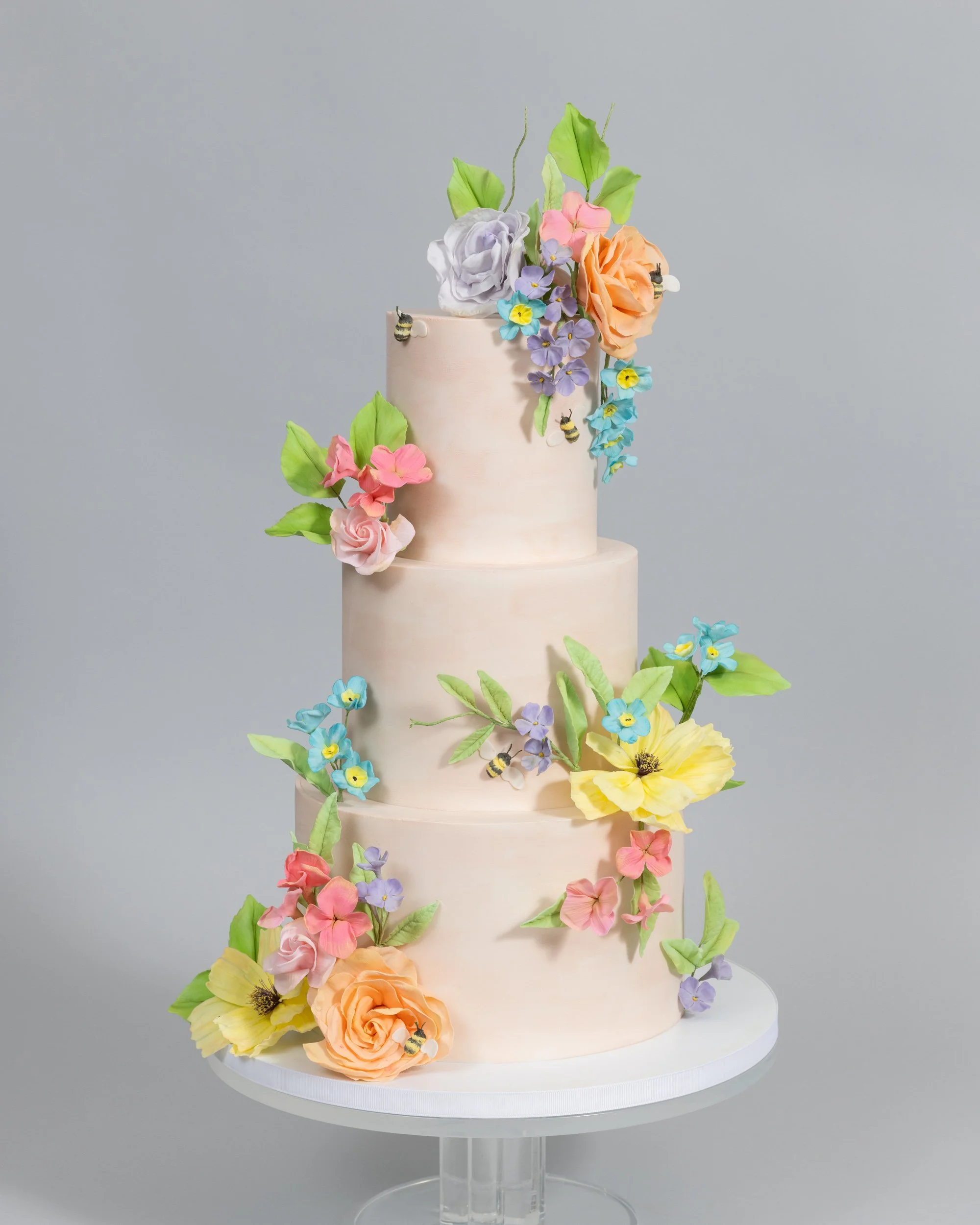Springtime pale peach wedding cake with colorful sugar flowers Cake Hero