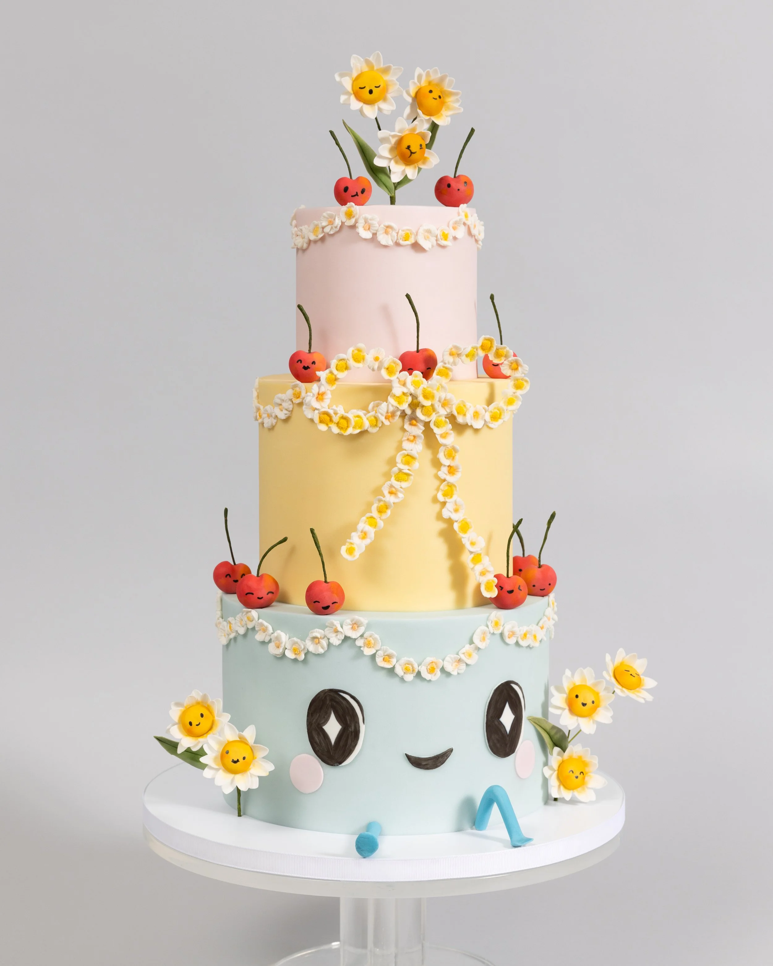 A smiling cake with happy flowers and cherries