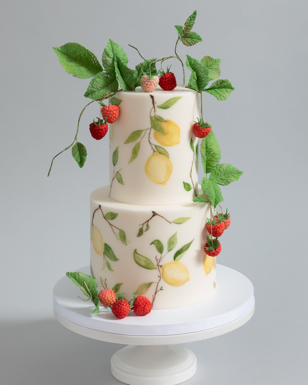 Hand painted lemon Tuscan cake with sugar raspberries and leaves