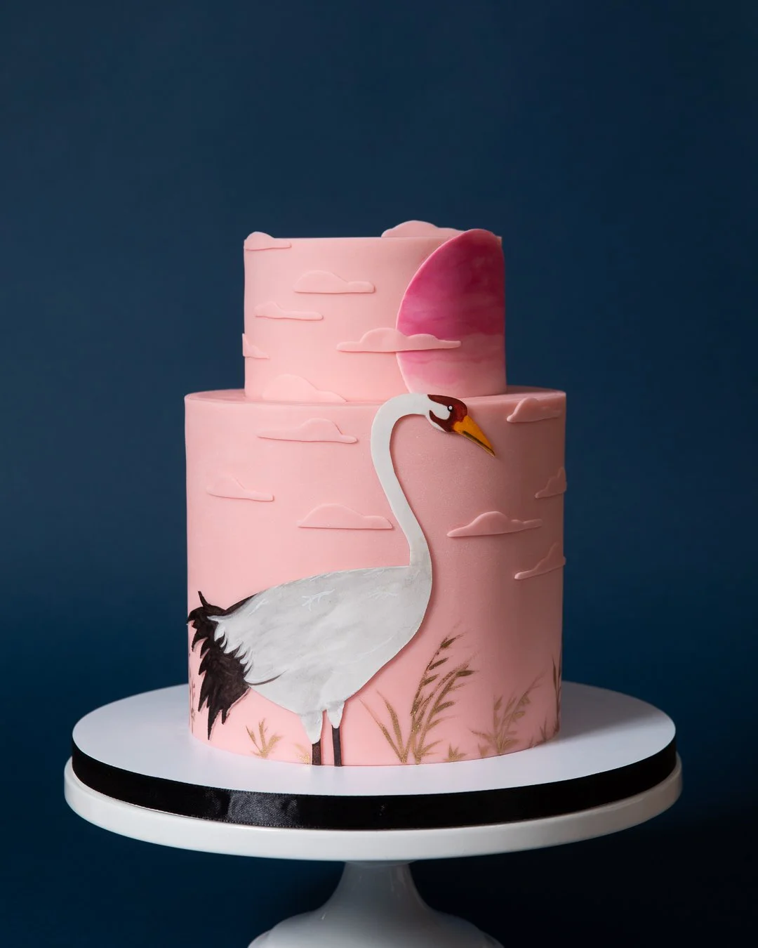 Pink crane birthday cake with dramatic setting sun